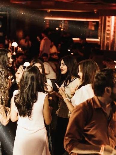 Guests laughing and chatting in a warmly lit Lucknow lounge